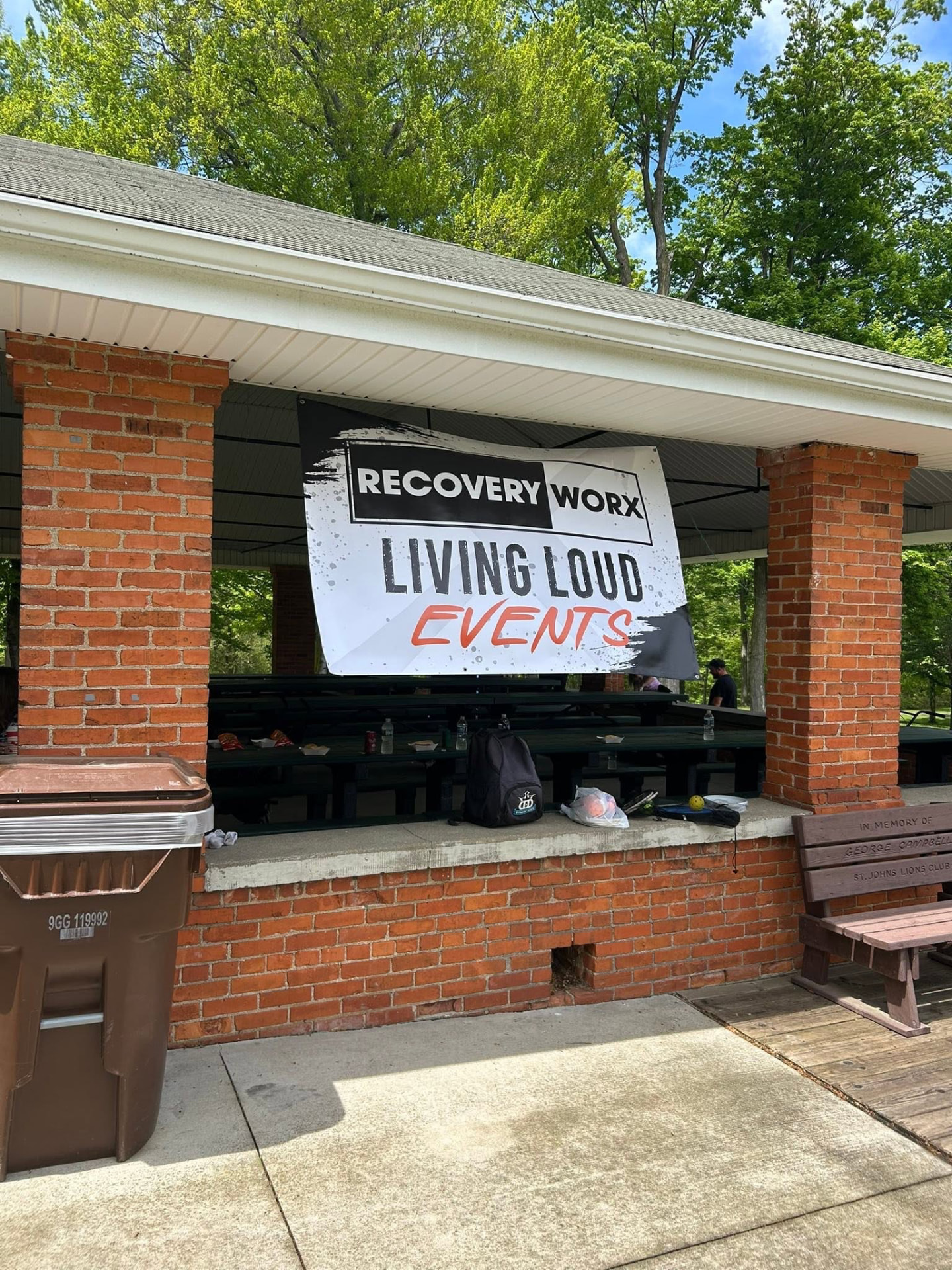 Recovery Worx Living Loud Events banner hanging at a park pavilion